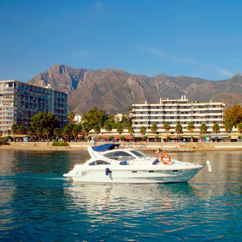 Luksusowy jacht na tle wybrzeża Marbella — przykład możliwości i stylu życia związanych z inwestowaniem w Hiszpanii.